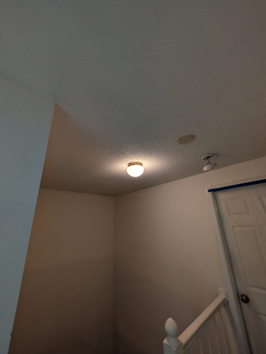 Popcorn ceiling before removal, room prepped with painter's tape