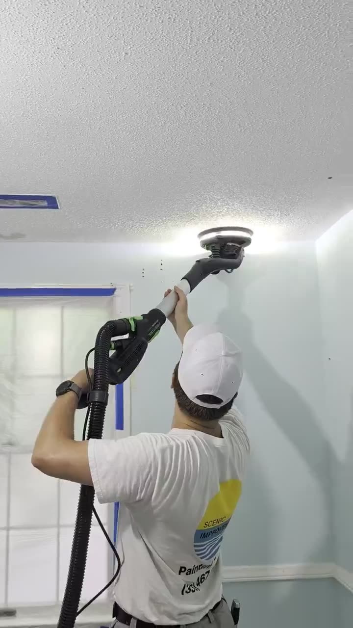 Scenic Improvements technician using a dust-free sander to remove popcorn ceiling texture